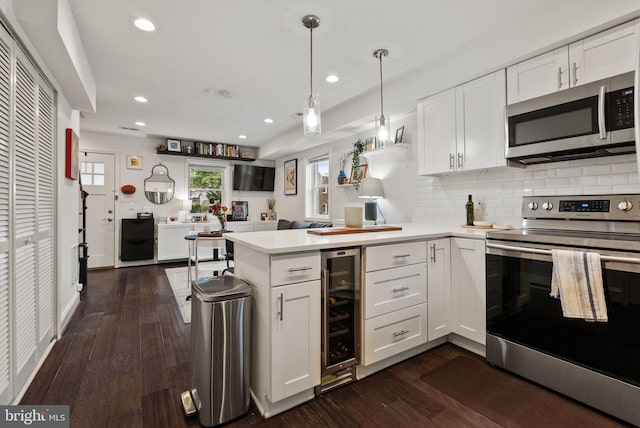 kitchen with white cabinets, a peninsula, and stainless steel appliances