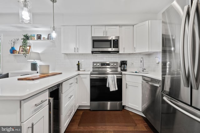 kitchen featuring beverage cooler, stainless steel appliances, a sink, white cabinets, and light countertops