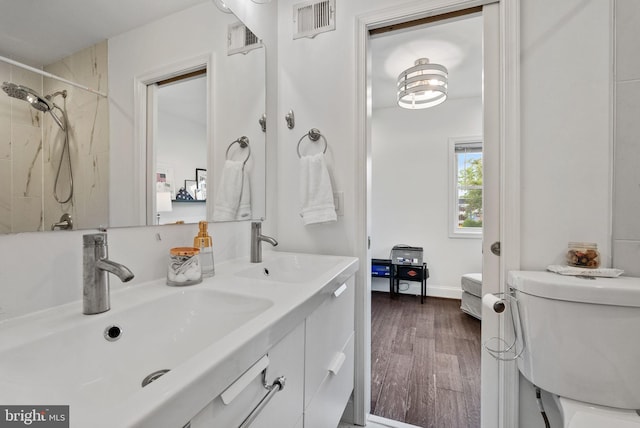 full bath with visible vents, a sink, and wood finished floors