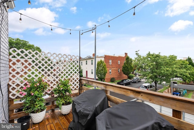 view of wooden balcony with a deck and a grill