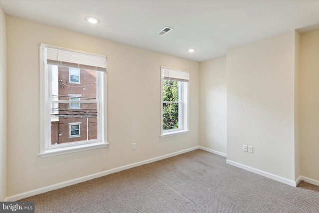 carpeted empty room with recessed lighting, visible vents, and baseboards