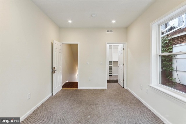 unfurnished room with carpet floors, recessed lighting, visible vents, and baseboards