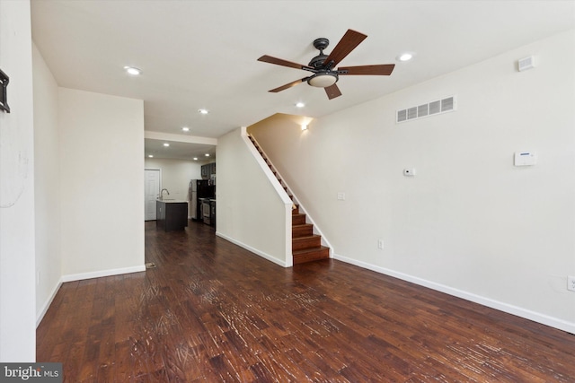 unfurnished living room with baseboards, visible vents, wood finished floors, stairs, and recessed lighting