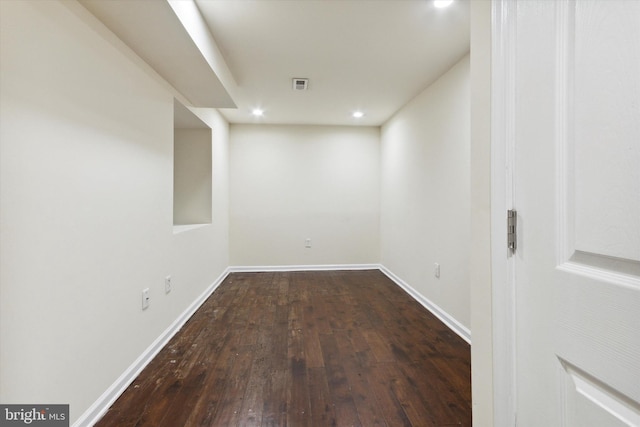 basement featuring baseboards, visible vents, dark wood-type flooring, and recessed lighting