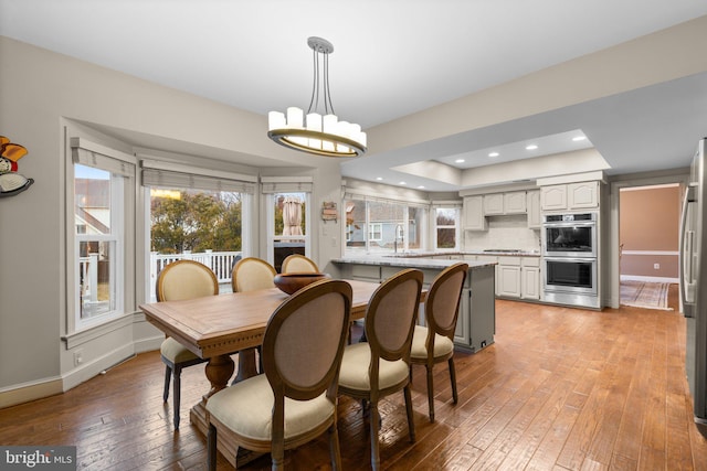 dining space featuring a notable chandelier, recessed lighting, baseboards, and light wood-style floors