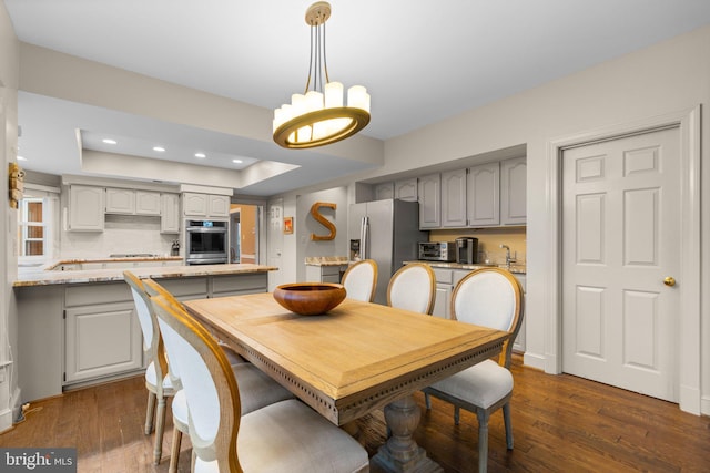 dining area featuring dark wood-style flooring, an inviting chandelier, and recessed lighting