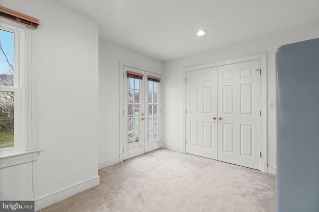 unfurnished bedroom featuring carpet, access to outside, baseboards, and french doors