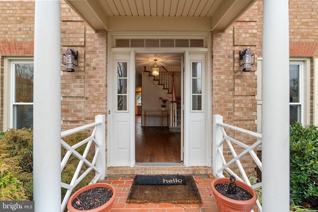 doorway to property featuring brick siding