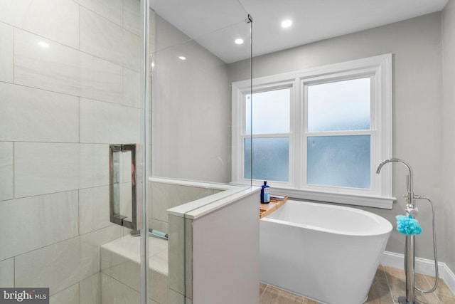 bathroom featuring a soaking tub, recessed lighting, baseboards, and a stall shower