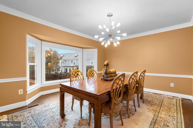 dining space with a chandelier, a wealth of natural light, visible vents, and crown molding