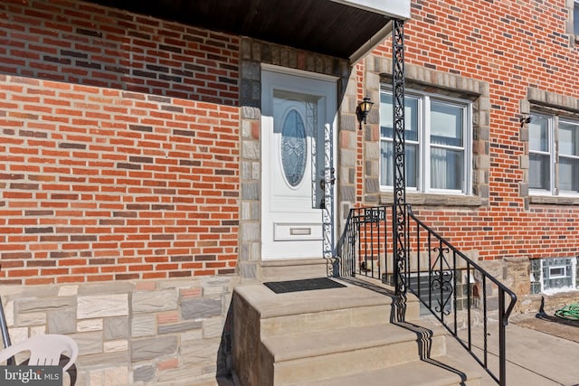 entrance to property featuring brick siding