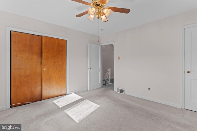 unfurnished bedroom with baseboards, visible vents, a ceiling fan, carpet floors, and a closet