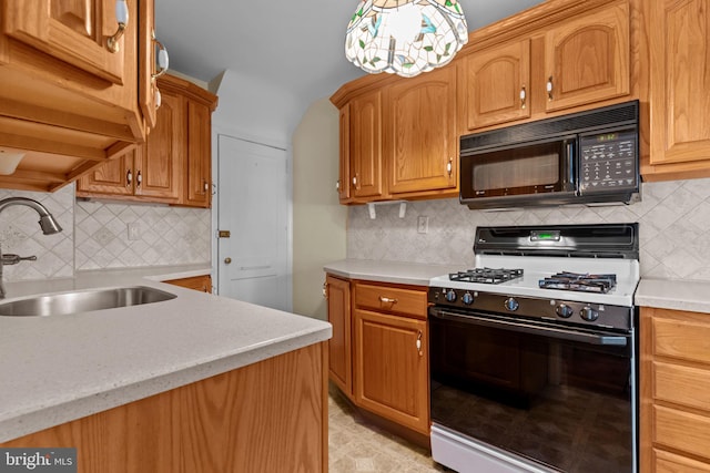 kitchen featuring range with gas cooktop, black microwave, light countertops, and a sink