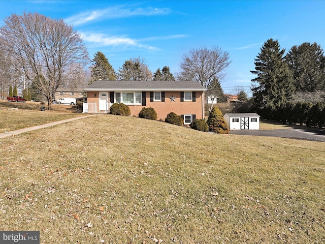 view of front facade with a front yard, brick siding, an outdoor structure, and a storage shed