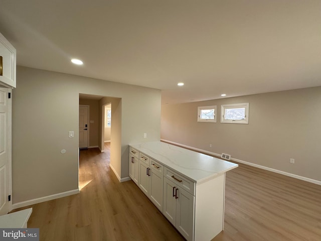 kitchen with light wood-style flooring, recessed lighting, a peninsula, visible vents, and white cabinetry