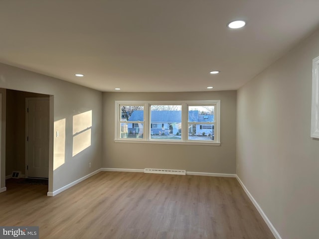 unfurnished room featuring recessed lighting, light wood-style flooring, and baseboards