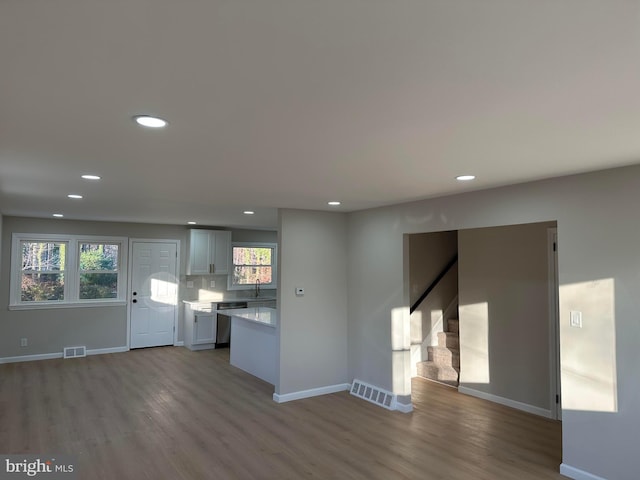 kitchen with baseboards, visible vents, stainless steel dishwasher, and wood finished floors