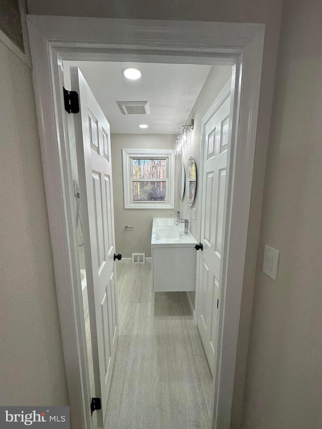 bathroom featuring visible vents, vanity, and wood finished floors