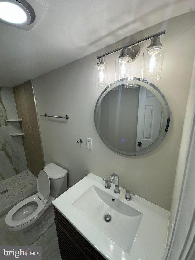 full bathroom featuring toilet, a shower stall, and vanity