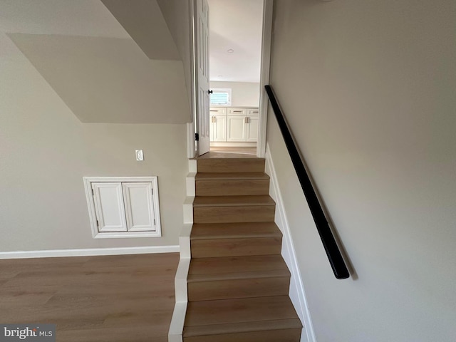 stairway featuring baseboards and wood finished floors