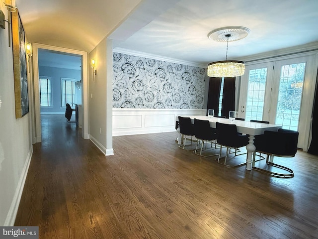 dining area featuring a wealth of natural light, a chandelier, dark wood-type flooring, and wainscoting