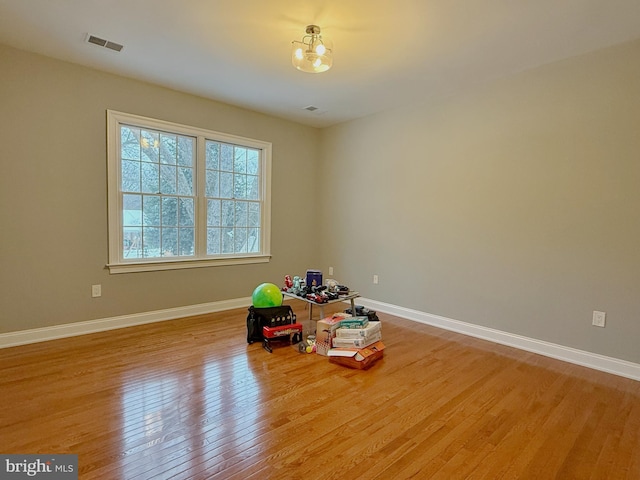 playroom with light wood-type flooring, visible vents, and baseboards