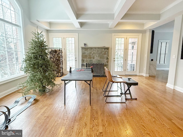 interior space with french doors, coffered ceiling, and light wood-style flooring