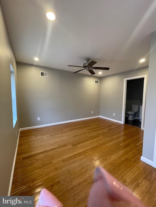 unfurnished living room featuring visible vents, a ceiling fan, baseboards, and wood finished floors