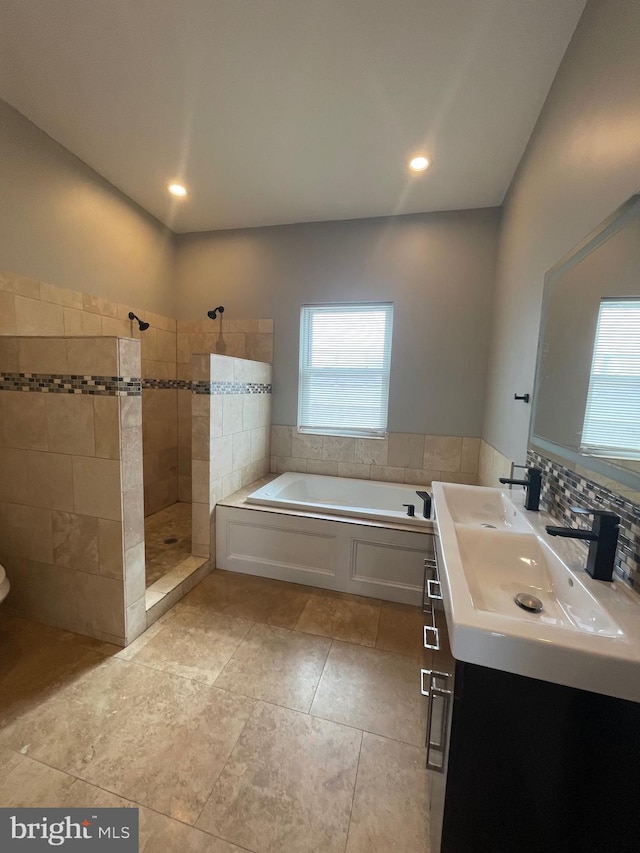 full bath featuring walk in shower, plenty of natural light, a bath, and vanity