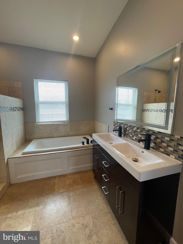 bathroom with a sink, a bath, and a wealth of natural light
