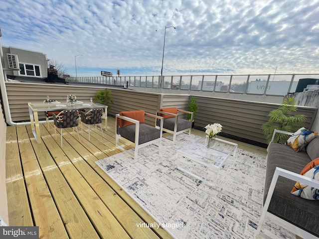 wooden deck with outdoor dining space and a water view