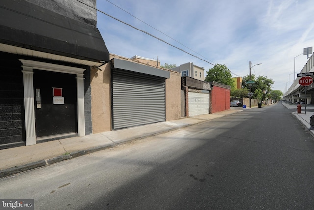 view of street featuring sidewalks, traffic signs, curbs, and street lights