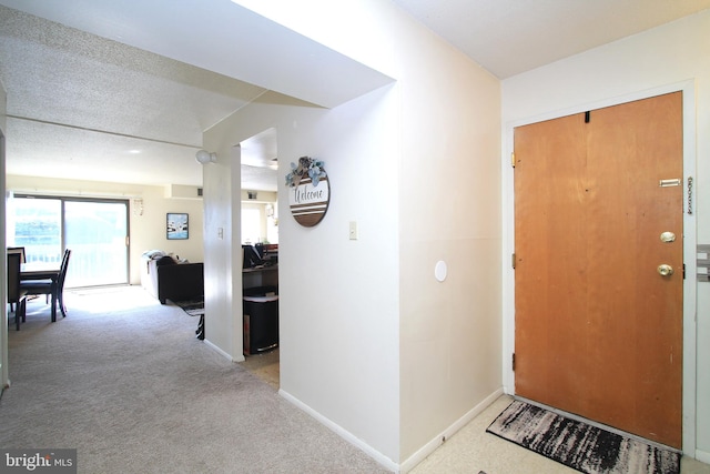 foyer with carpet floors and baseboards