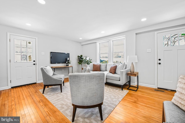 living room featuring recessed lighting, baseboards, and hardwood / wood-style floors