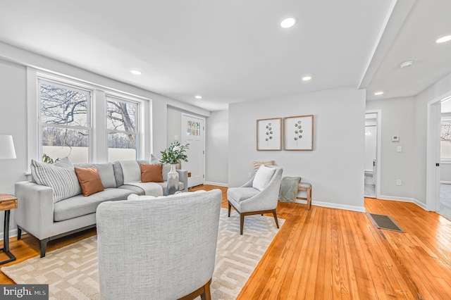 living area with light wood finished floors, baseboards, visible vents, and recessed lighting