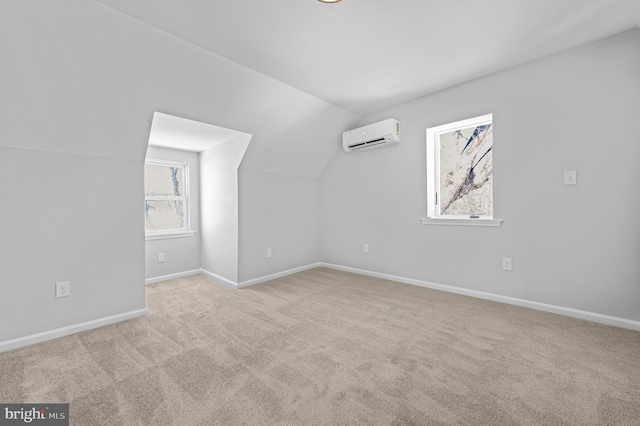 additional living space with light carpet, vaulted ceiling, baseboards, and a wall mounted AC