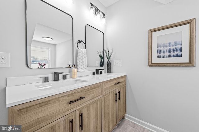 bathroom featuring double vanity, baseboards, and a sink