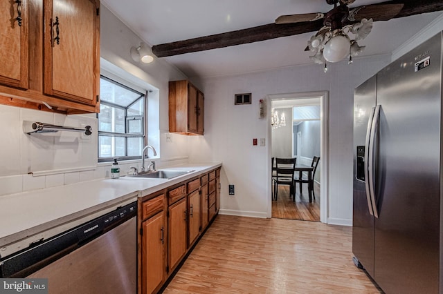 kitchen with visible vents, brown cabinetry, appliances with stainless steel finishes, light wood-style floors, and a sink