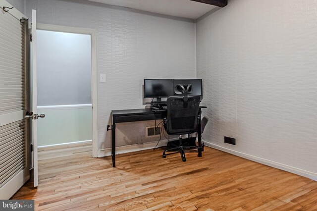 office area featuring baseboards, visible vents, and wood finished floors