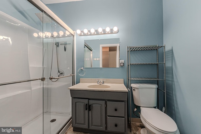 full bathroom featuring toilet, a shower stall, and vanity