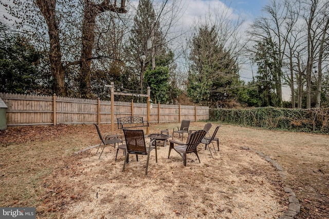 view of yard featuring a fenced backyard and a fire pit