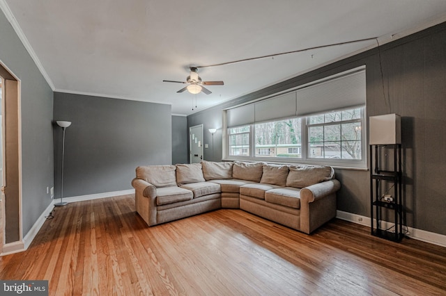 living room with baseboards, crown molding, hardwood / wood-style floors, and ceiling fan