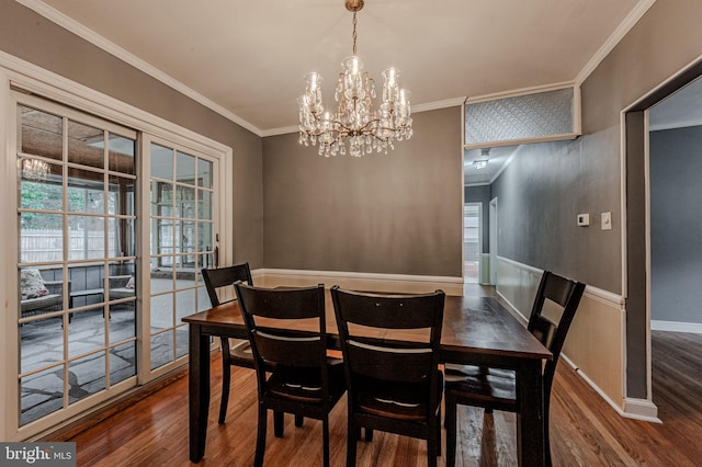 dining area with a notable chandelier, baseboards, wood finished floors, and crown molding