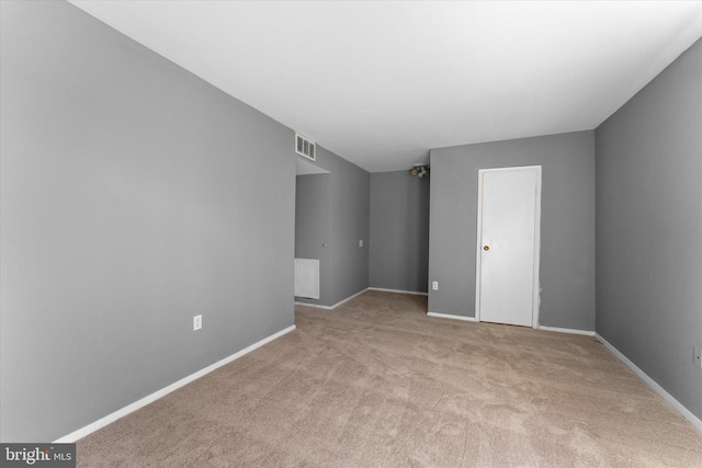 carpeted empty room with visible vents and baseboards