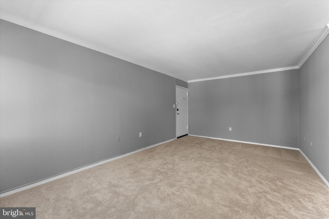 empty room with light carpet, baseboards, and crown molding