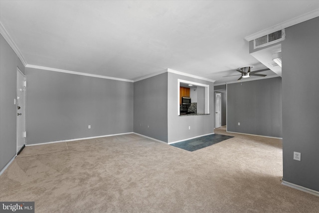 interior space with visible vents, baseboards, a ceiling fan, carpet, and crown molding