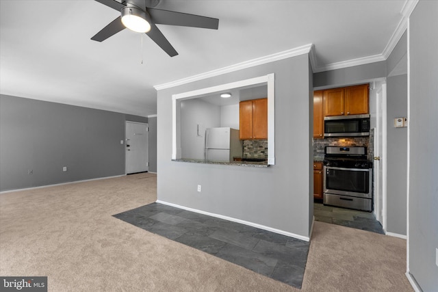 kitchen with brown cabinets, stainless steel appliances, dark colored carpet, backsplash, and baseboards