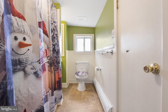 full bath featuring a baseboard radiator, toilet, visible vents, baseboards, and tile patterned floors