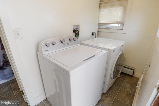 laundry room featuring a baseboard heating unit, laundry area, separate washer and dryer, and dark tile patterned flooring