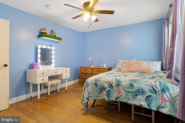 bedroom featuring a ceiling fan, baseboards, and wood finished floors